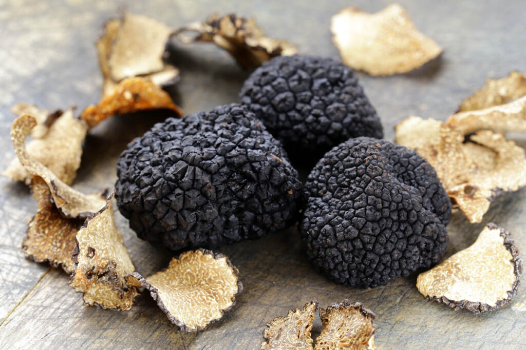 rare and expensive black truffels on a wooden background