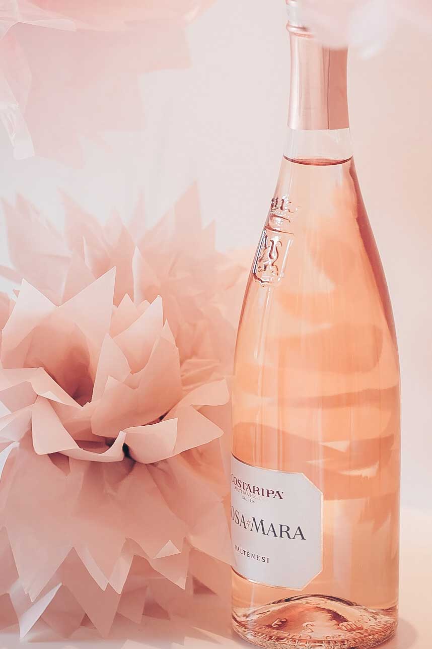 A bottle of Costaripa Valtènesi Rosé wine with a a pink origami flower in the background