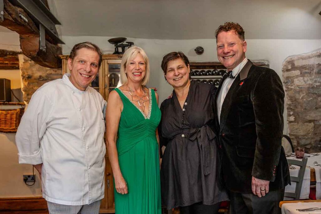 A photo capturing the head chef and owner of La Locanda alongside his wife, sharing a moment with the two talented opera singers who graced the restaurant with their performance.