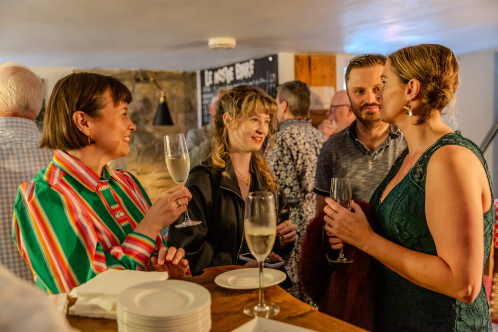 Guests chatting and enjoying white wine at a gathering.